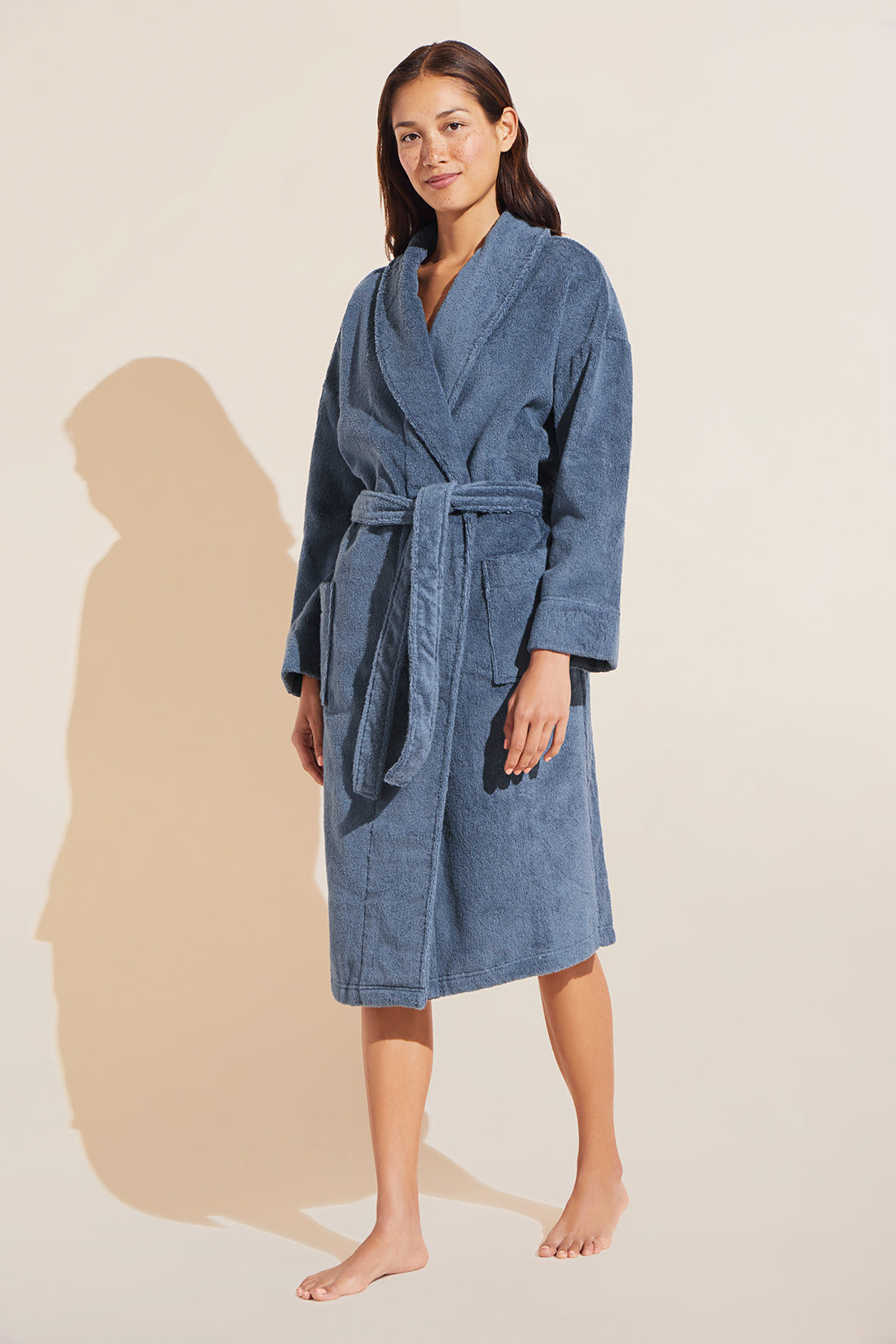 Model wears Terry Gender Neutral Robe in Coastal Blue.