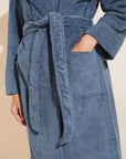 Model wears Terry Gender Neutral Robe in Coastal Blue.