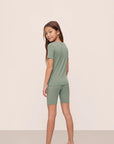 Model is wearing Kids TENCEL™ Modal Unisex Short PJ Set in Eucalyptus/Ivory