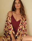 Model is wearing Inez Washable Silk Long Robe in Botanical Flower Merlot and Washable Silk Lace Cami and Short Set in Merlot/Merlot