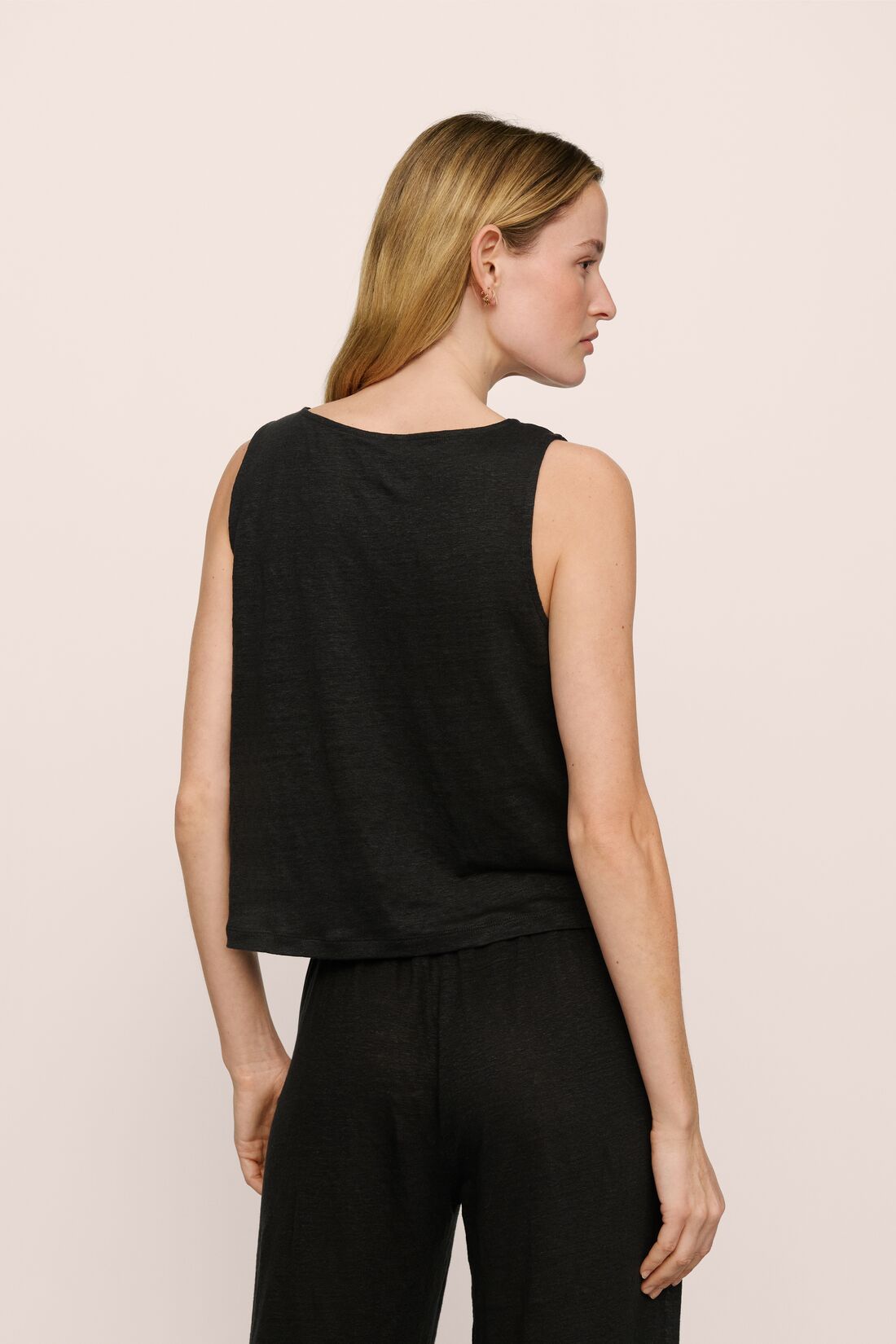 Model is wearing Organic Linen Knit Boat Neck Crop Tank in Black