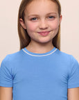 Model is wearing the Kids TENCEL™ Modal Unisex Short PJ Set in cornflower blue/white
