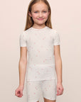Model is wearing the Kids Printed TENCEL™ Modal Unisex Short PJ Set in Summer Daisy/Pale Mauve