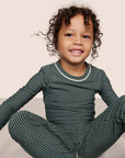 Model is wearing Kids Printed TENCEL™ Modal Unisex Long PJ Set in Duo Stripe Pine/Ivory