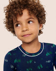 Model is wearing Kids Printed TENCEL™ Modal Unisex Long PJ Set in Forest Pine Navy/Ivory