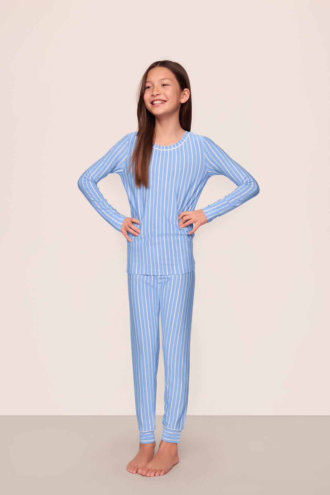 Model is wearing Kids Printed TENCEL™ Modal Unisex Long PJ Set in Nordic Stripe Vista Blue/White