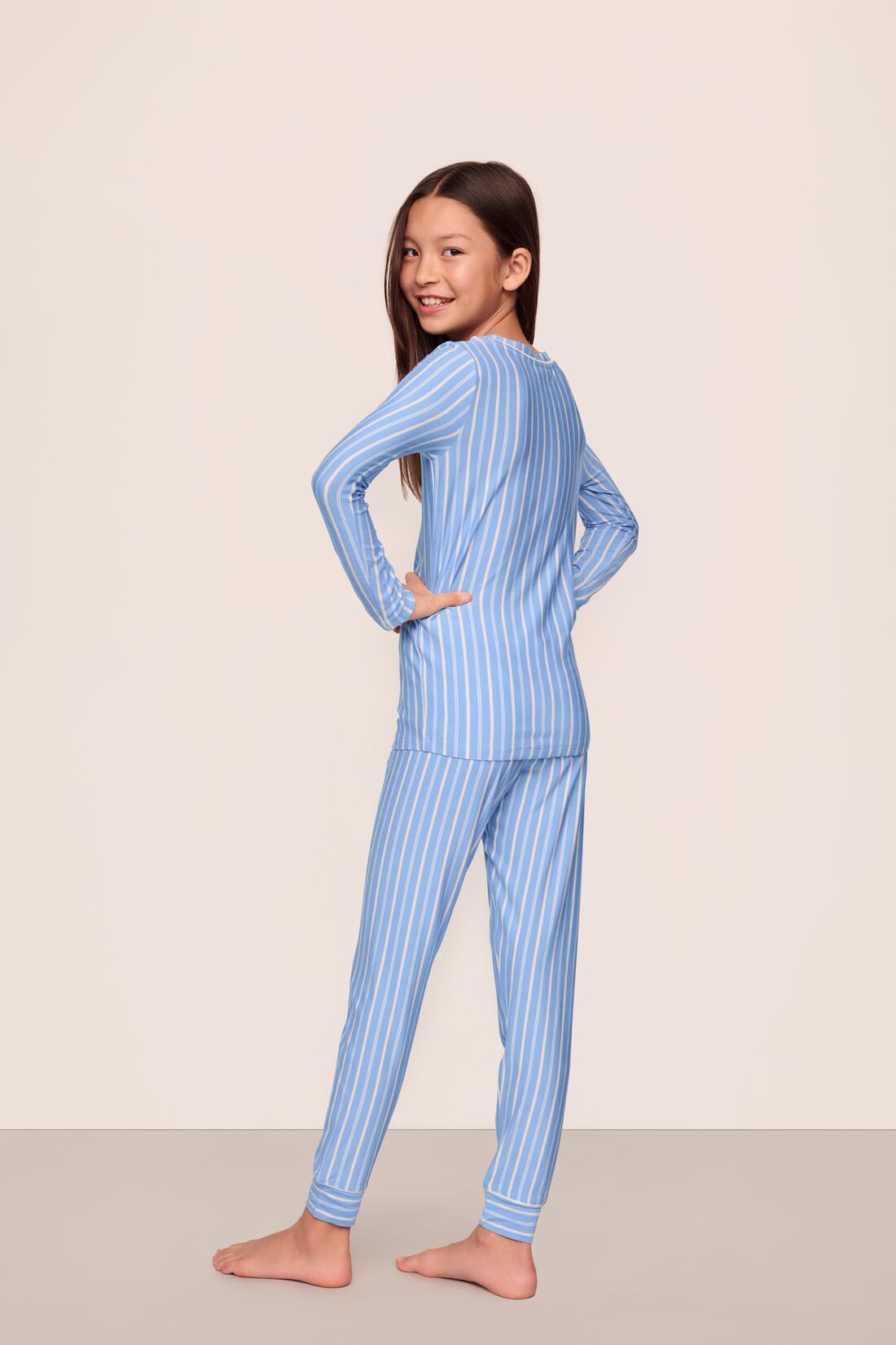 Model is wearing Kids Printed TENCEL™ Modal Unisex Long PJ Set in Nordic Stripe Vista Blue/White