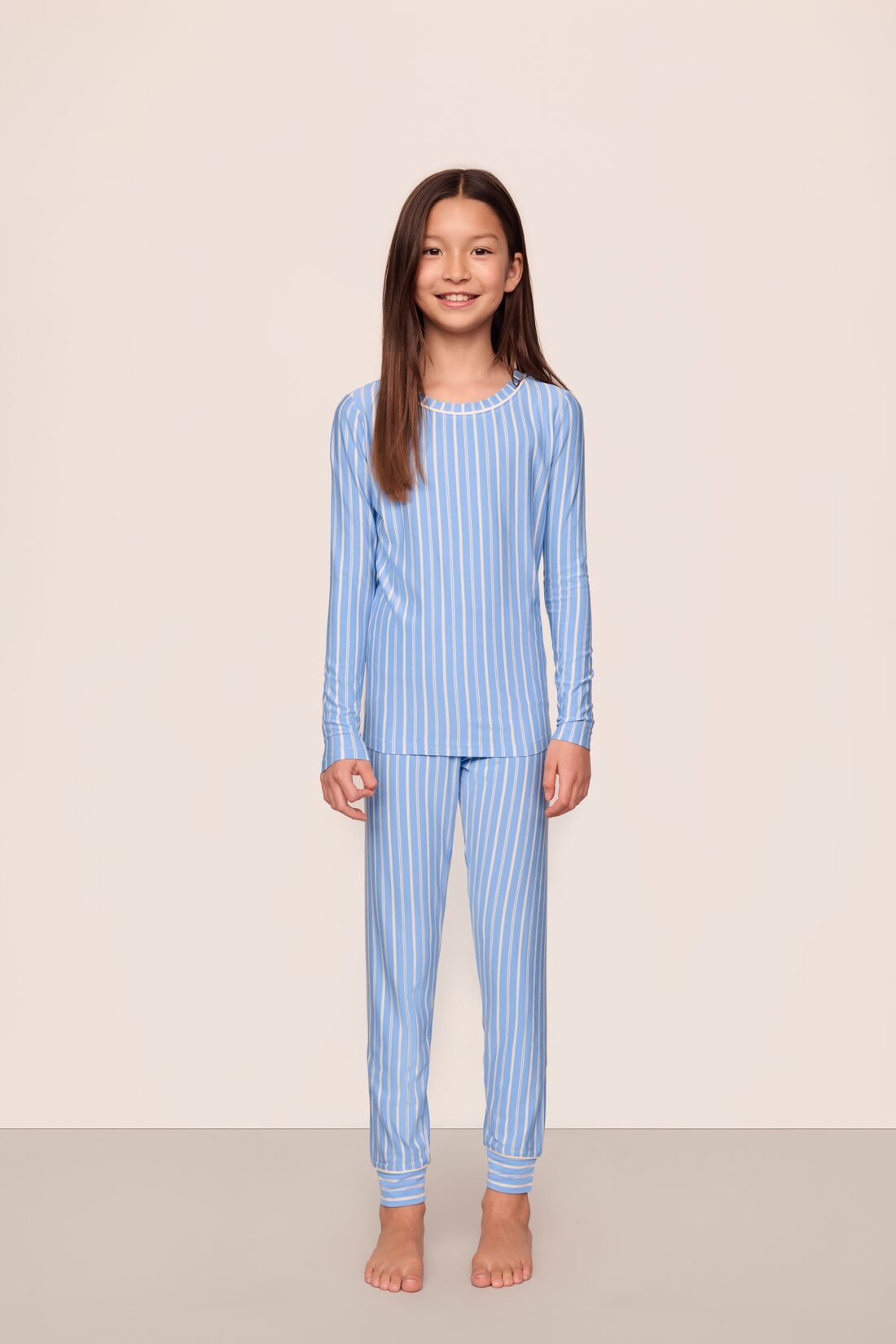 Model is wearing Kids Printed TENCEL™ Modal Unisex Long PJ Set in Nordic Stripe Vista Blue/White