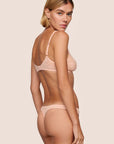 Model is wearing Soft Stretch Lace Thong in Buff