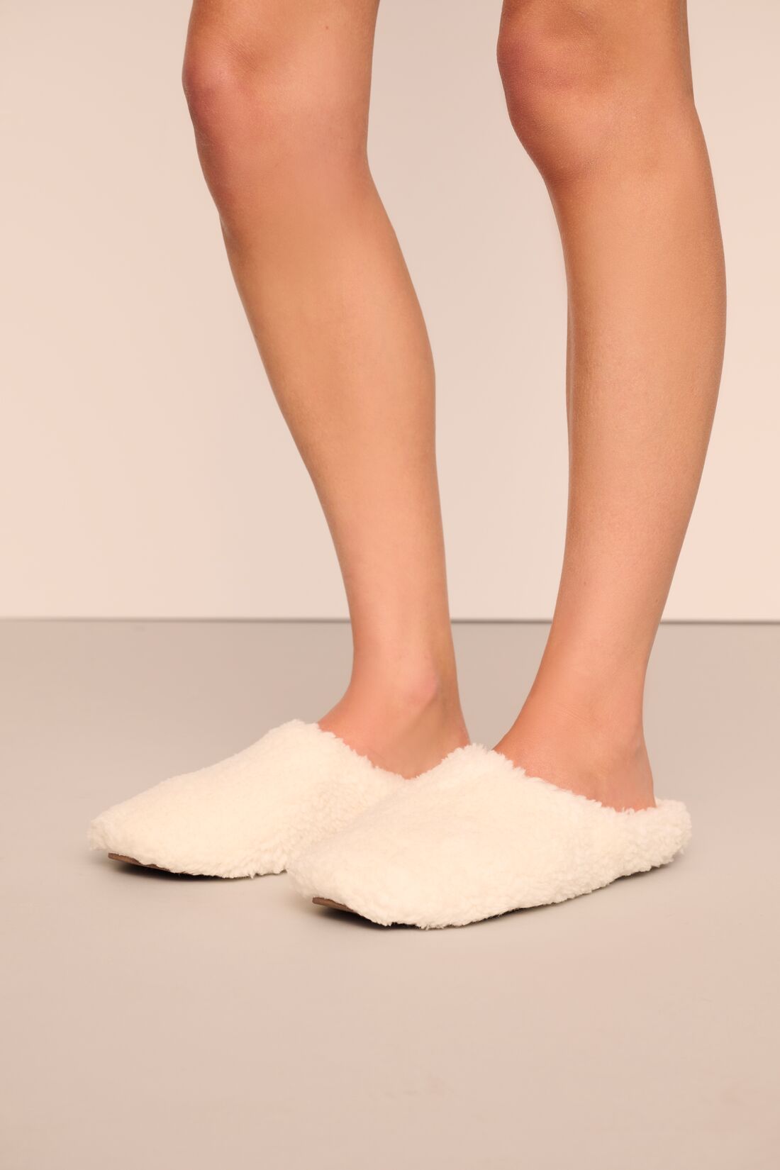 Model is wearing sherpa slipper in ivory
