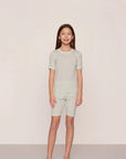 Model is wearing Kids Printed TENCEL™ Modal Unisex Short PJ Set in Tide Dot Ivory/Ivory