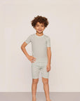Model is wearing Kids Printed TENCEL™ Modal Unisex Short PJ Set in Tide Dot Ivory/Ivory