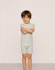 Model is wearing Kids Printed TENCEL™ Modal Unisex Short PJ Set in Tide Dot Ivory/Ivory