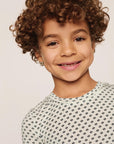 Model is wearing Kids Printed TENCEL™ Modal Unisex Short PJ Set in Tide Dot Ivory/Ivory