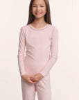 Model is wearing Kids TENCEL™ Modal Unisex Long PJ Set in Pale Pink/Fig