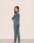 Model is wearing Kids TENCEL™ Modal Unisex Long PJ Set in Stone Blue/Ivory