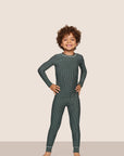 Model is wearing Kids Printed TENCEL™ Modal Unisex Long PJ Set in Duo Stripe Pine/Ivory