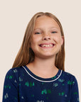 Model is wearing Kids Printed TENCEL™ Modal Unisex Long PJ Set in Forest Pine Navy/Ivory