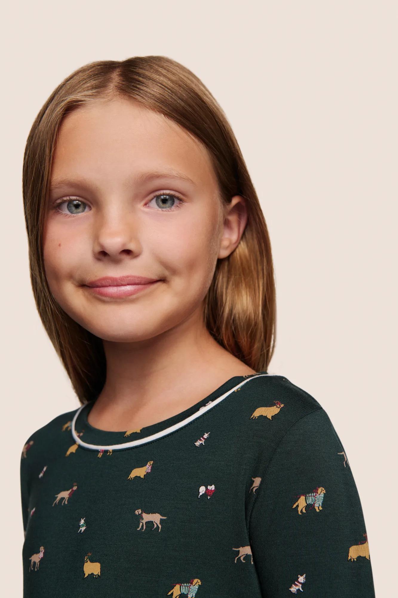 Model is wearing Kids Printed TENCEL™ Modal Unisex Long PJ Set  in Holiday Dogs Pine/Ivory