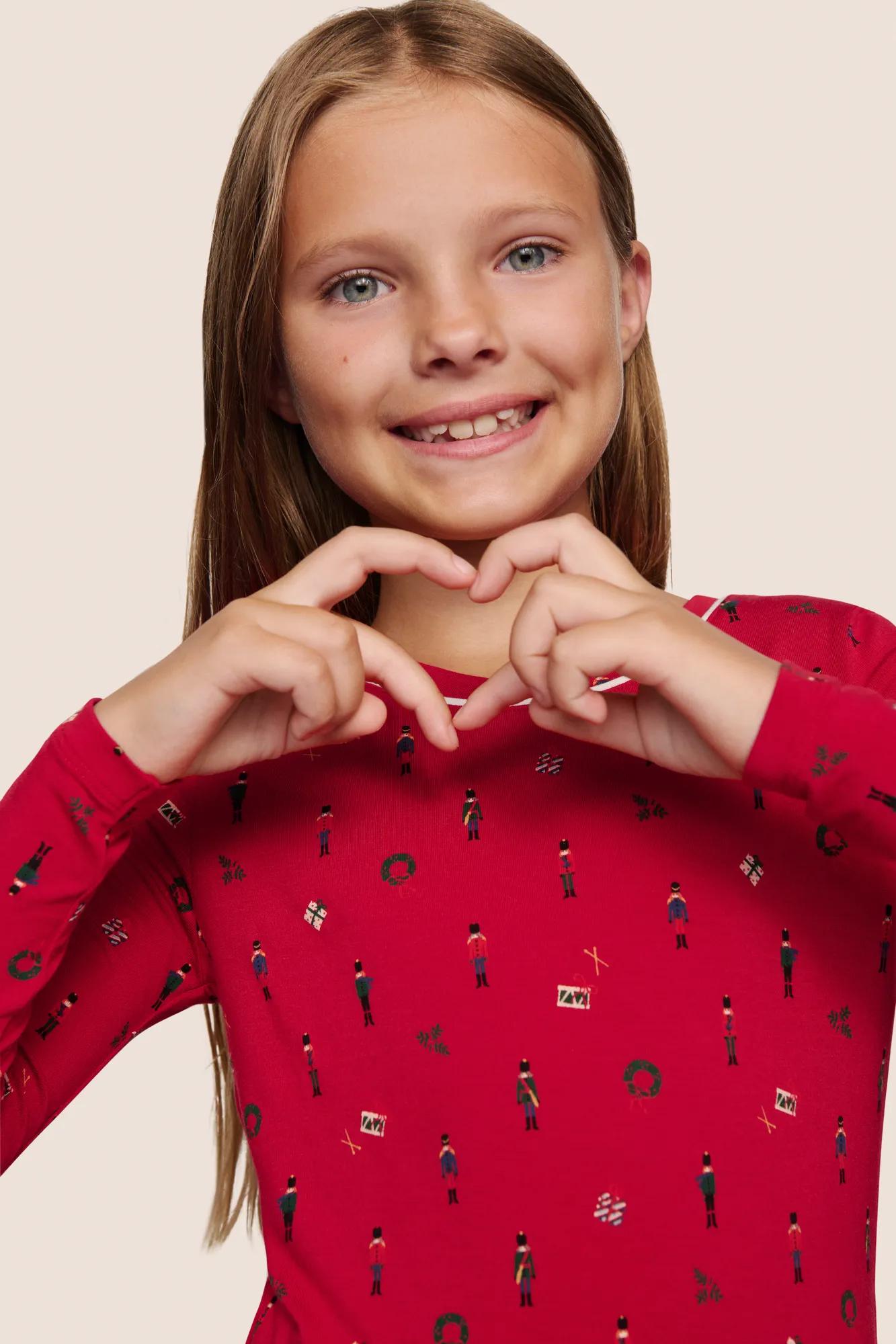 Model is wearing Kids Printed TENCEL™ Modal Unisex Long PJ Set  in Nutcracker Holly Red/Ivory