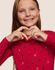 Model is wearing Kids Printed TENCEL™ Modal Unisex Long PJ Set in Nutcracker Holly Red/Ivory