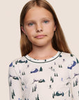 Model is wearing Kids Printed TENCEL™ Modal Unisex Long PJ Set in Ski Chalet Ivory/Pine