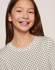 Model is wearing Kids Printed TENCEL™ Modal Unisex Long PJ Set in Tide Dot Ivory/Ivory