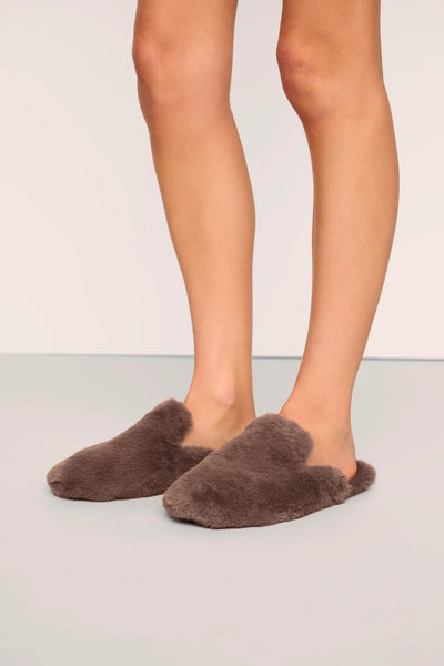 Model is wearing Plush Mule Slipper in Deep Taupe