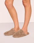 Model is wearing Plush Mule Slipper in Toffee