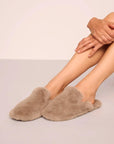 Model is wearing Plush Mule Slipper in Toffee