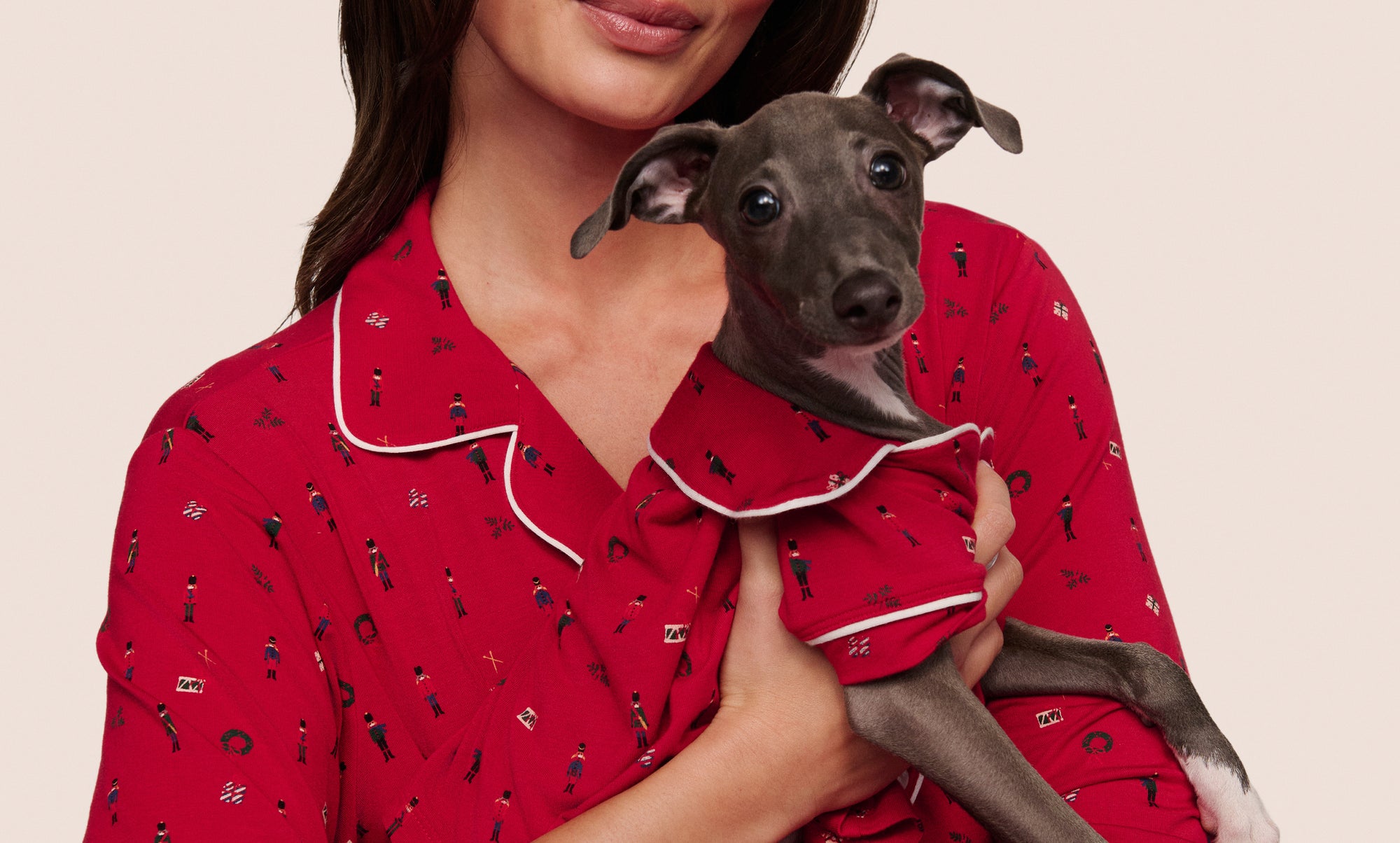 Model and dog wearing matching PJs in  Nutcracker Holly Red/Ivory