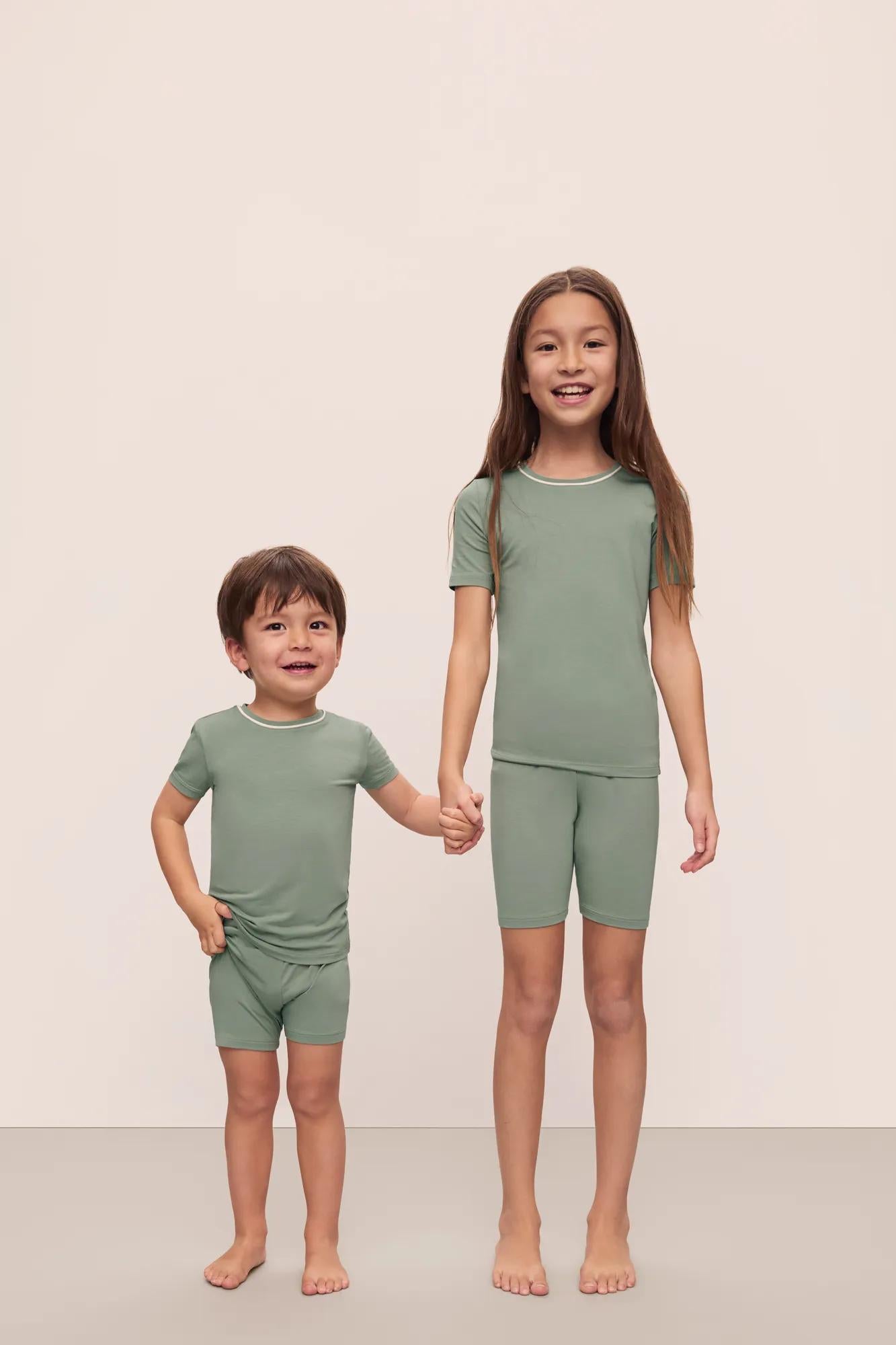 Model is wearing Kids TENCEL™ Modal Unisex Short PJ Set in Eucalyptus/Ivory