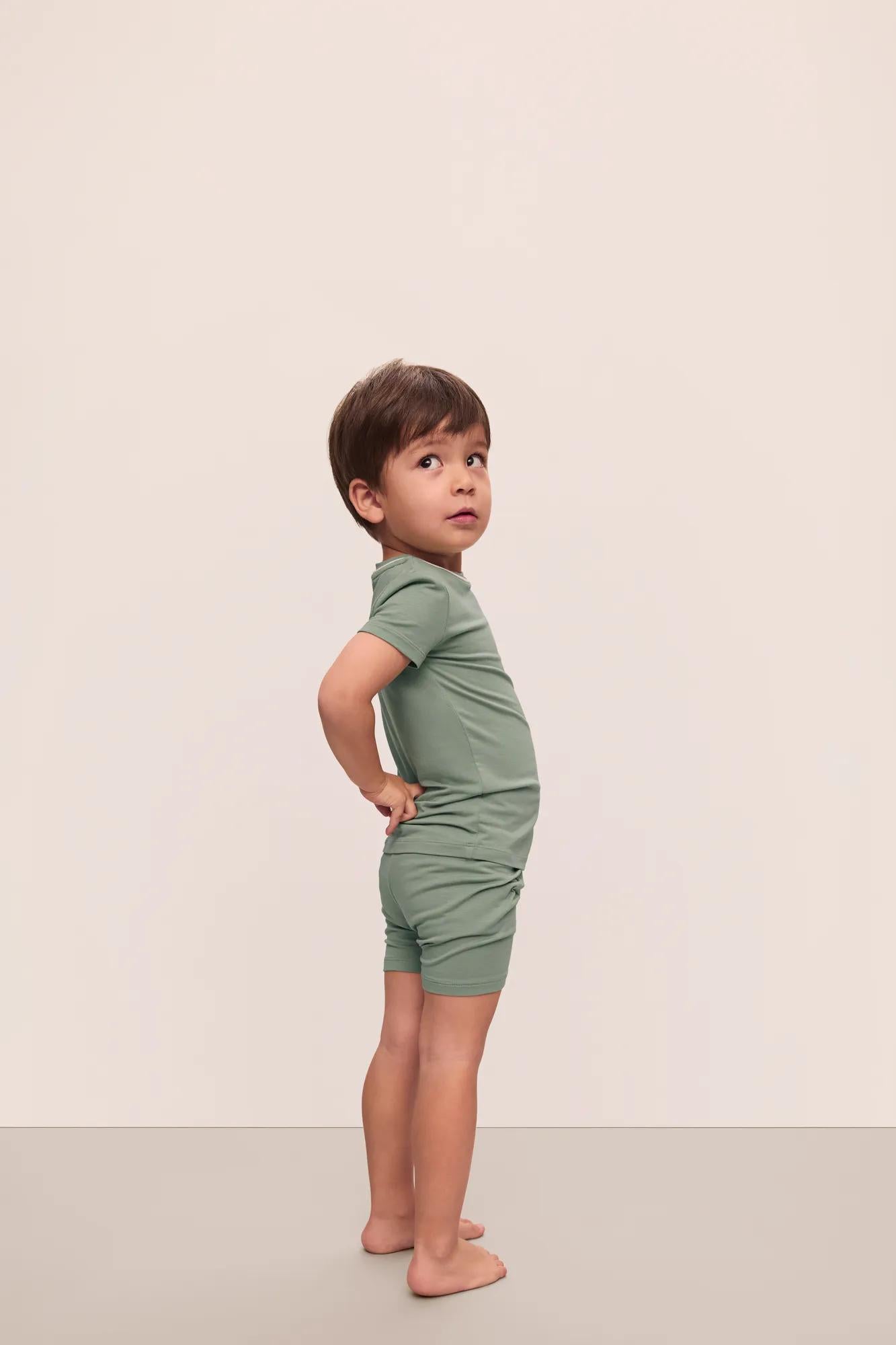 Model is wearing Kids TENCEL™ Modal Unisex Short PJ Set in Eucalyptus/Ivory