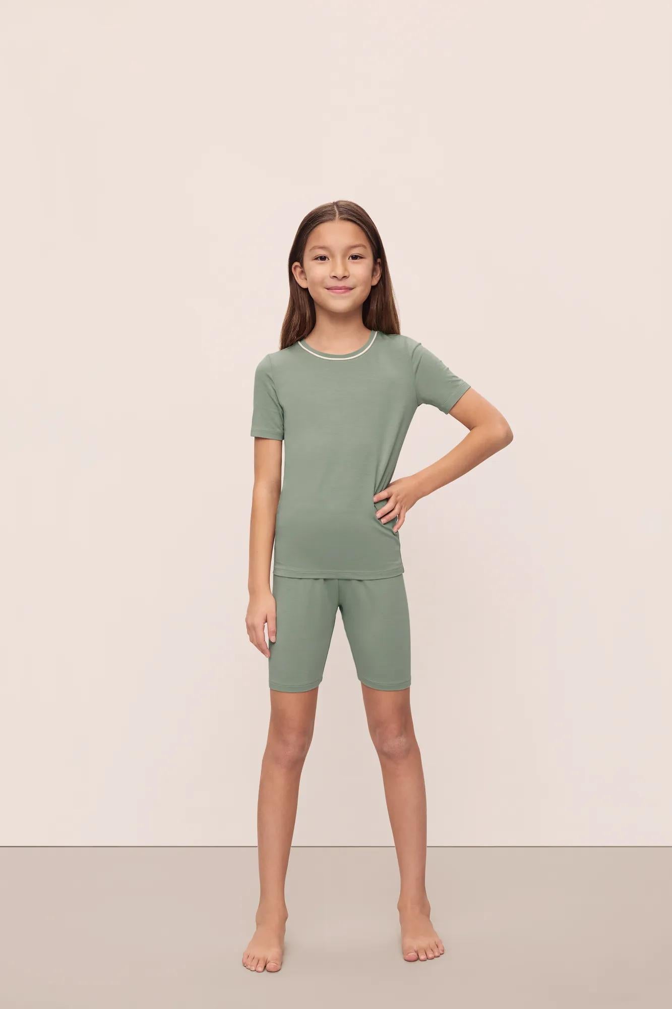 Model is wearing Kids TENCEL™ Modal Unisex Short PJ Set in Eucalyptus/Ivory