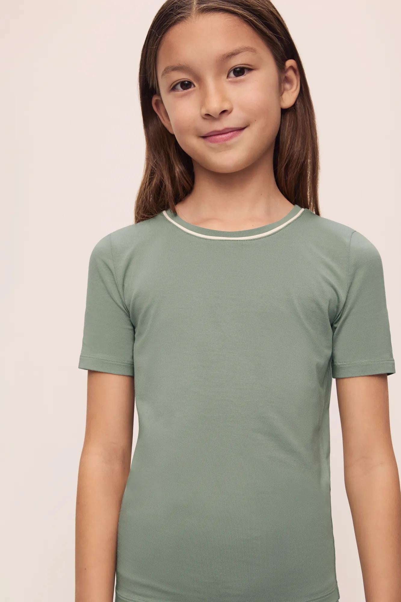 Model is wearing Kids TENCEL™ Modal Unisex Short PJ Set in Eucalyptus/Ivory