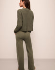 Model wears Recycled Sweater Pant in Moss.