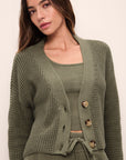 Model is Wearing the Recycled Sweater Cropped Cardigan in Moss.