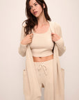 Model wears Recycled Sweater Short Wrap in Oat.