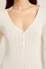 Model wears Pointelle V Neck Henley in Ivory.