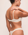 Model is wearing Soft Stretch Recycled Lace Thong in Ivory