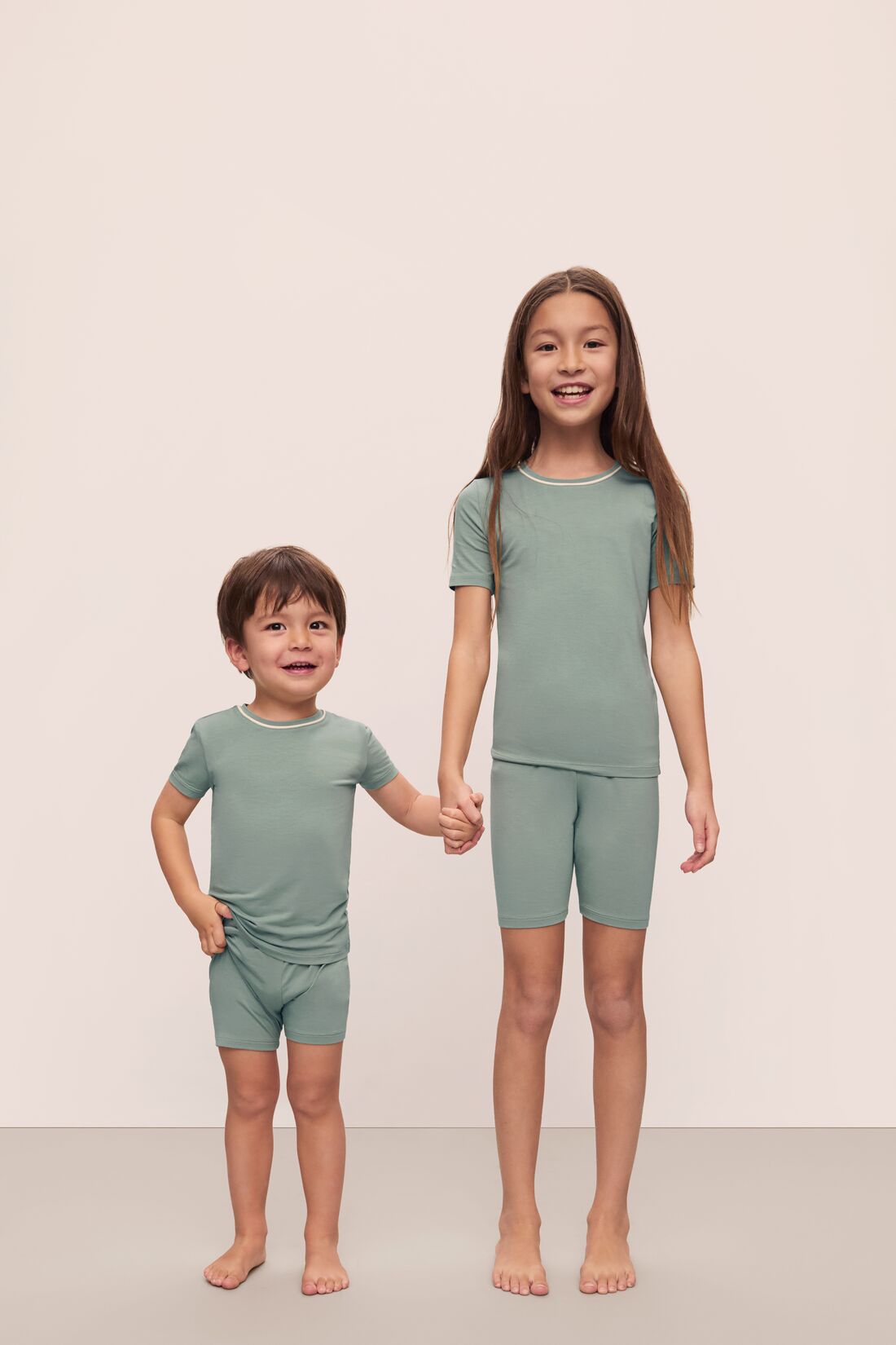 Models are wearing Kids TENCEL™ Modal Unisex Short PJ Set in Eucalyptus/Ivory