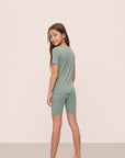 Model is wearing Kids TENCEL™ Modal Unisex Short PJ Set in Eucalyptus/Ivory