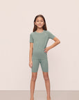 Model is wearing Kids TENCEL™ Modal Unisex Short PJ Set in Eucalyptus/Ivory