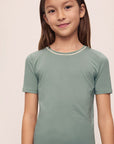 Model is wearing Kids TENCEL™ Modal Unisex Short PJ Set in Eucalyptus/Ivory