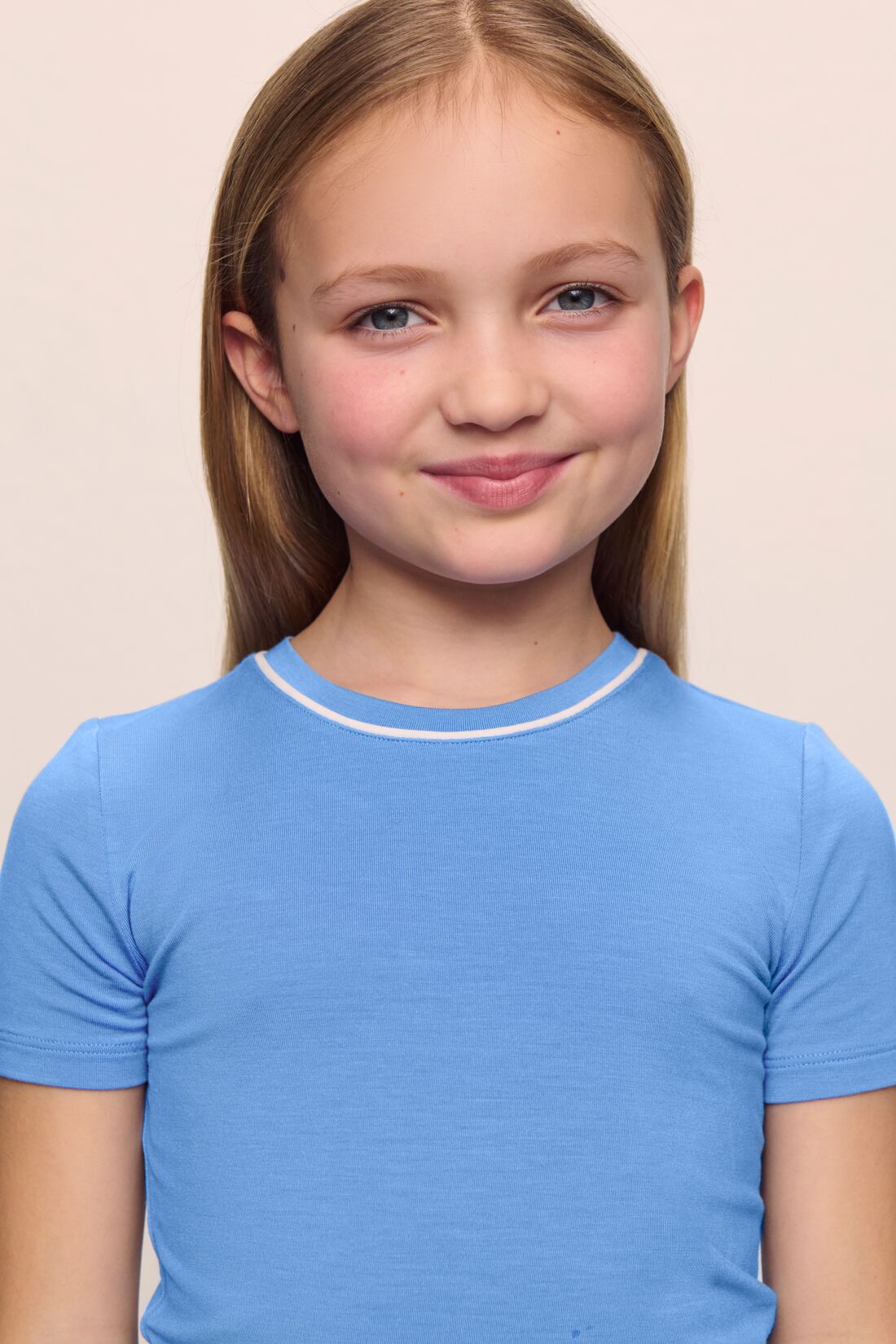 Model is wearing the Kids TENCEL™ Modal Unisex Short PJ Set in cornflower blue/white