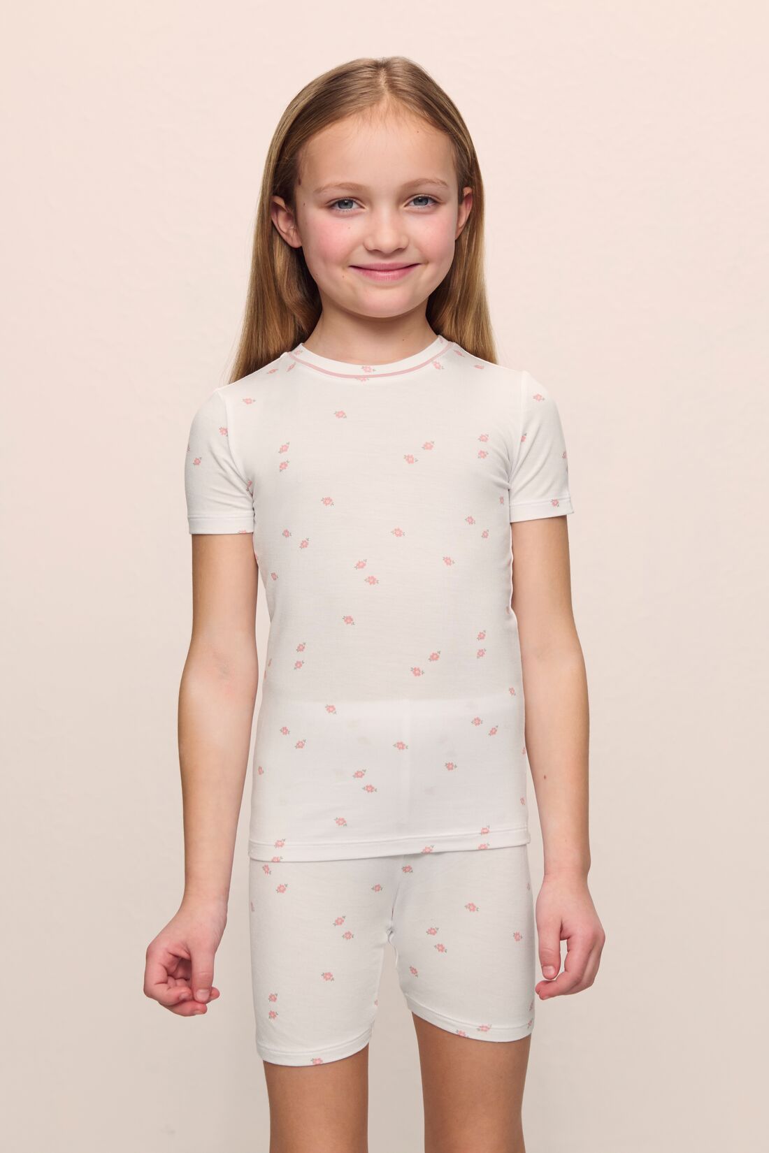 Model is wearing the Kids Printed TENCEL™ Modal Unisex Short PJ Set in Summer Daisy/Pale Mauve