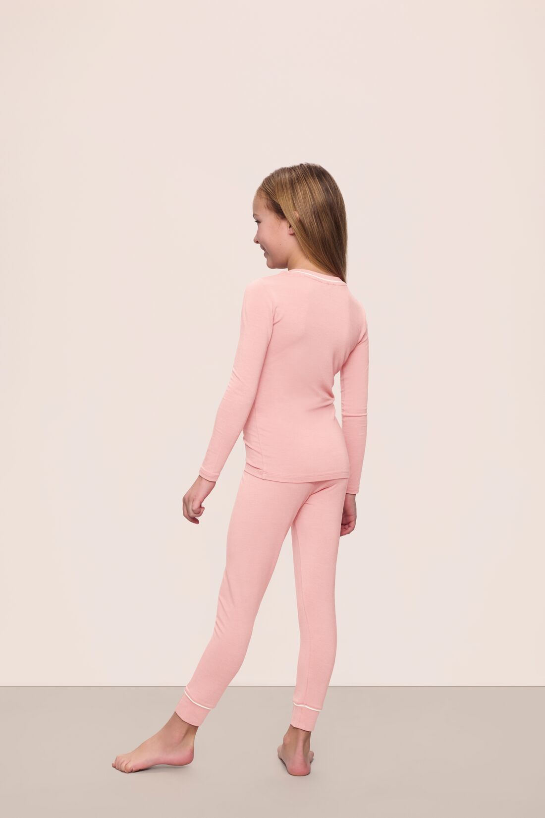 Model is wearing Kids TENCEL™ Modal Unisex Long PJ Set in Silver Pink/Ivory