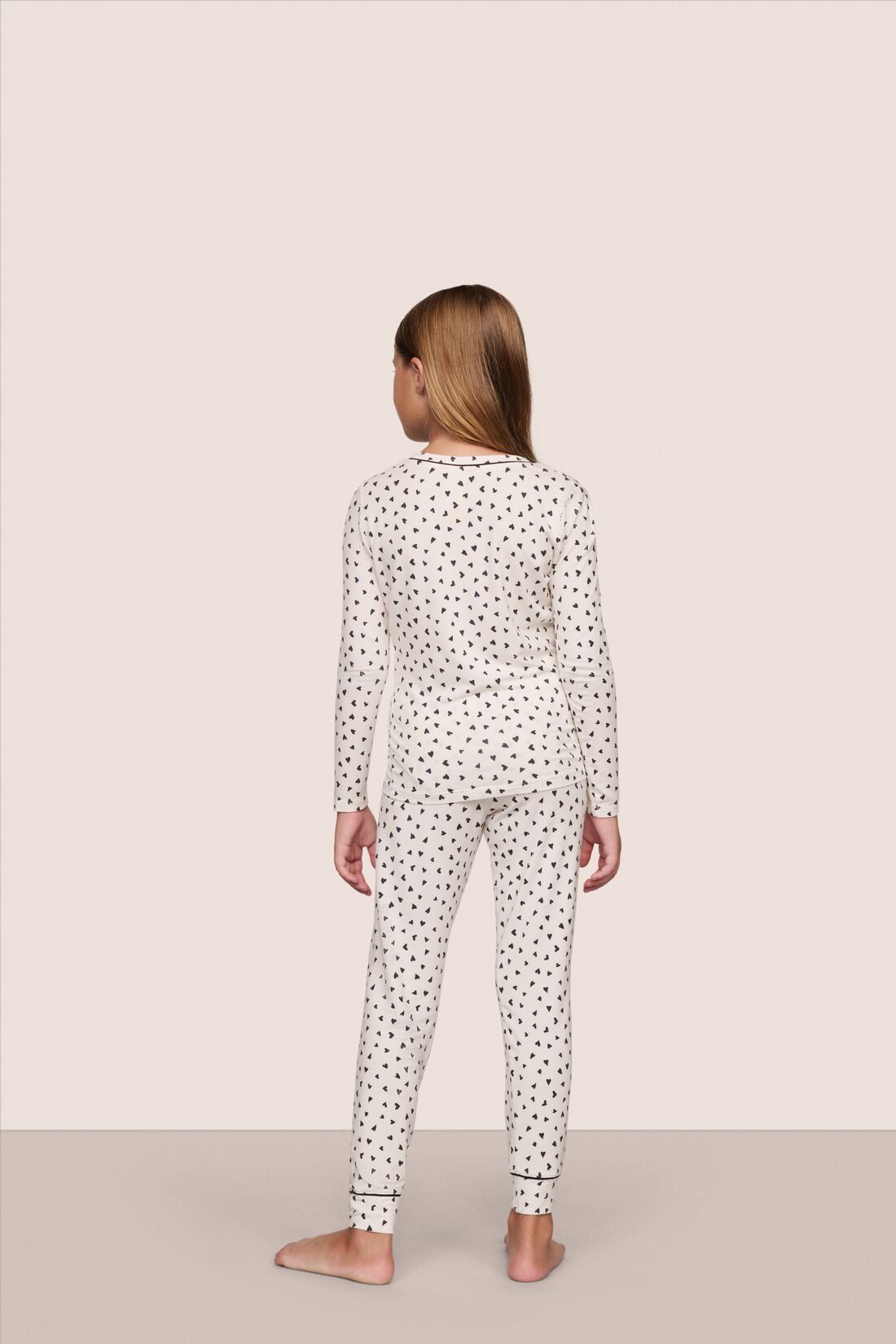 Model is wearing Kids Printed TENCEL™ Modal Unisex Long PJ Set  in Heart To Heart Black/Blk