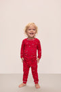 Model wears Kids Printed TENCEL™ Modal Unisex Long PJ Set in Winter Wonderland Haute Red/Ivory.