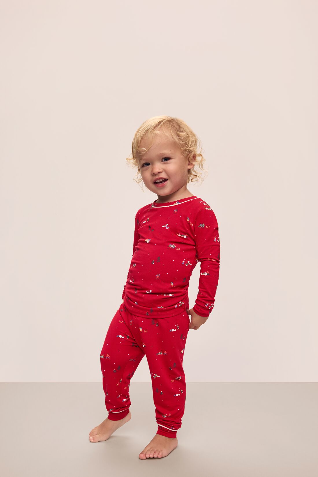 Model wears Kids Printed TENCEL™ Modal Unisex Long PJ Set in Winter Wonderland Haute Red/Ivory.